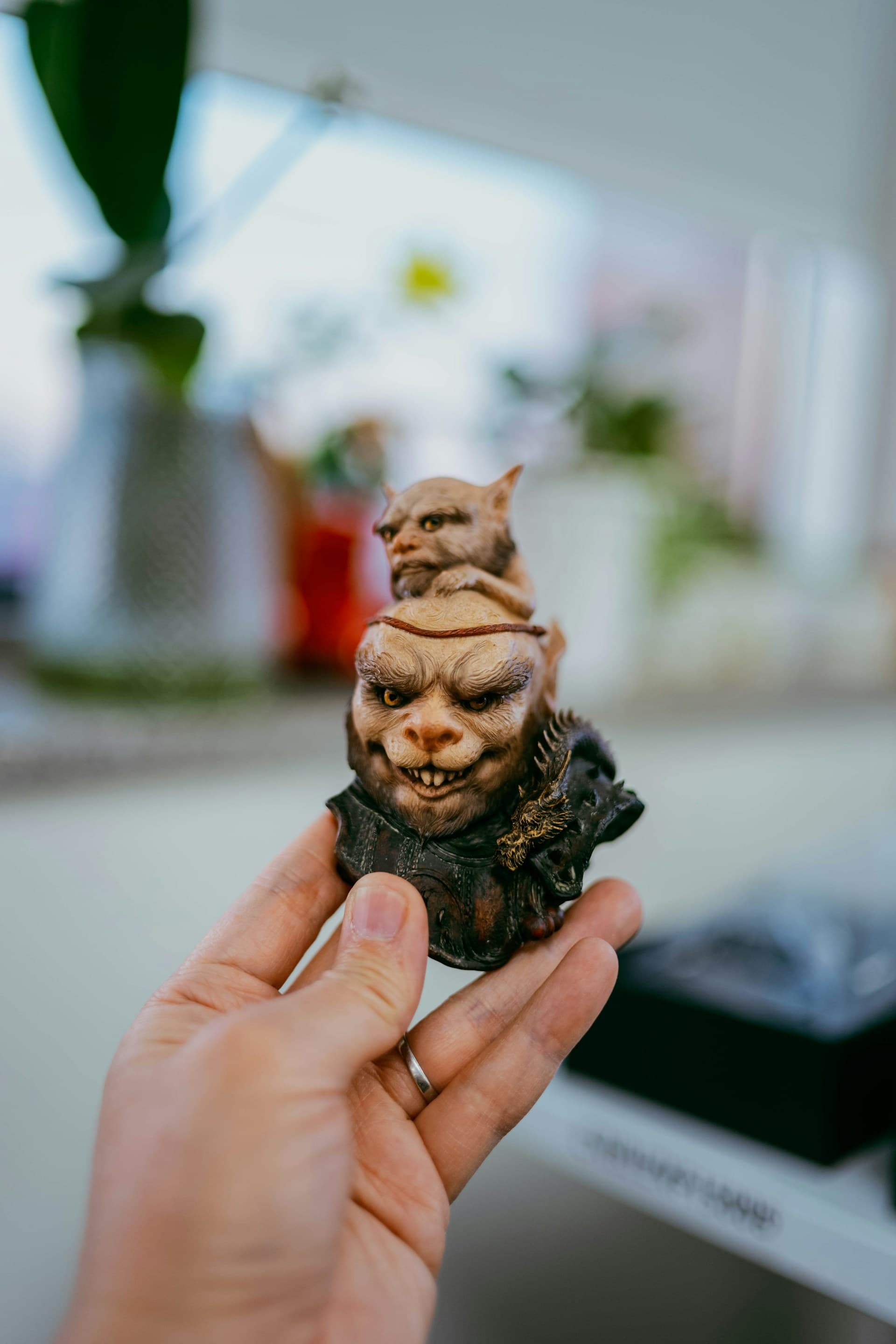 Hand holding a small, highly detailed hand-painted resin figurine bust