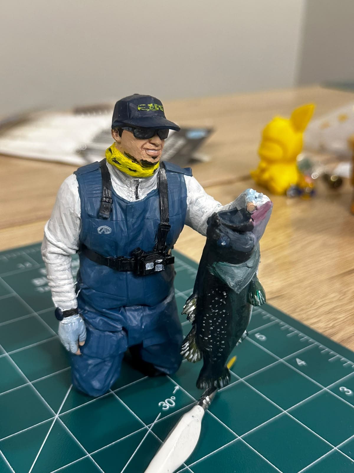 Custom hand-painted figurine of a fisherman holding his catch